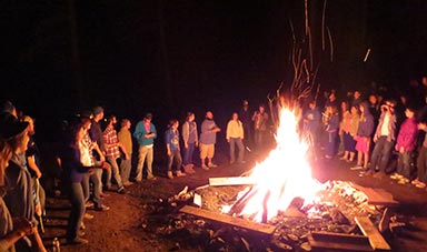 night time with camps surroundign a bonfire
