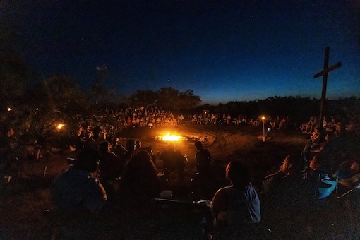 Group sitting around a campfire at night